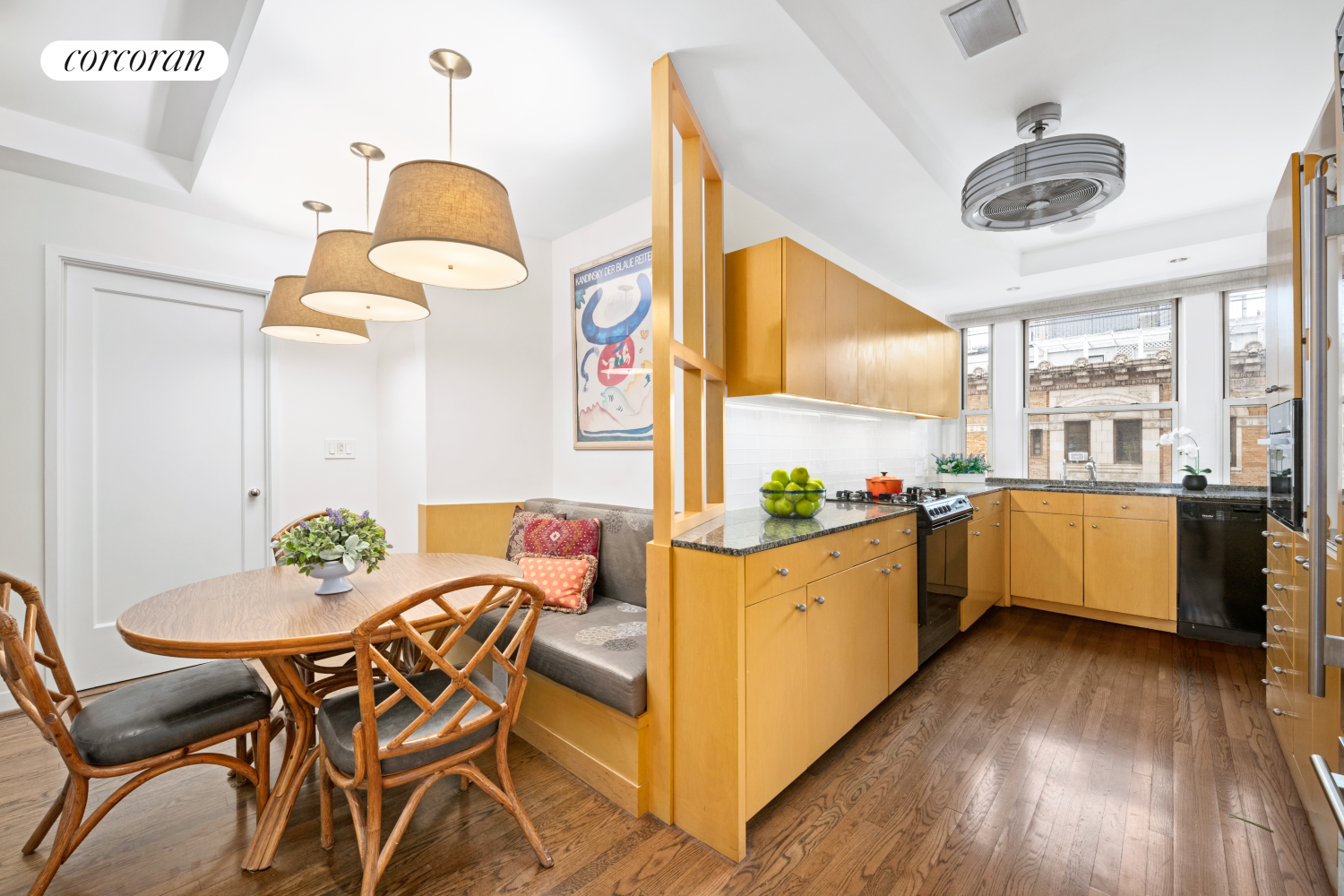 135 East 74th Street, Unit 11BC Manhattan, NY 10021 - Photo 6 of 13 a kitchen with stainless steel appliances kitchen island granite countertop a table and chairs in it