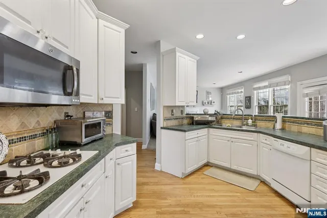 a kitchen with stainless steel appliances kitchen island granite countertop a sink and stove top oven