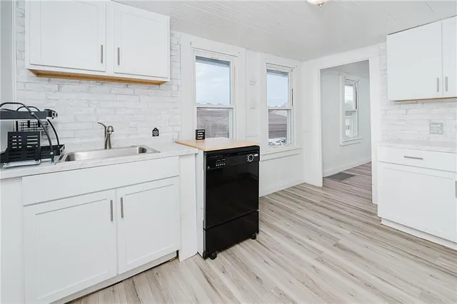 a kitchen with a sink dishwasher a refrigerator and cabinets