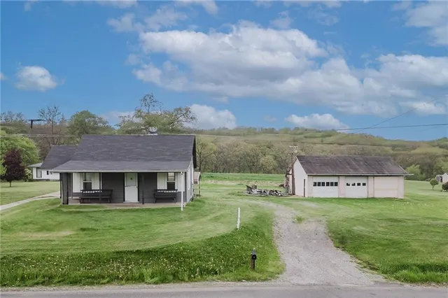 a view of a house with a big yard and large tree
