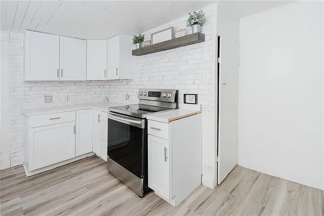a kitchen with cabinets appliances and wooden floor