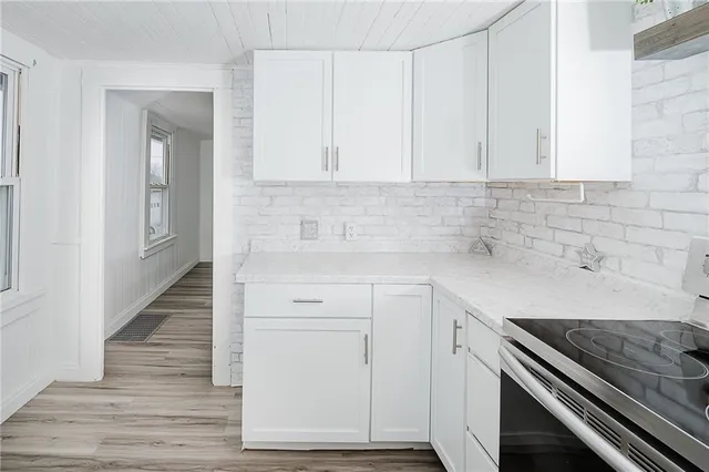 a kitchen with white cabinets and a stove