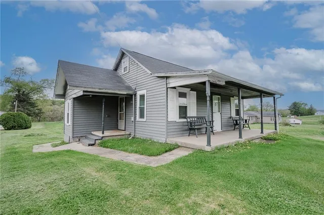 a view of a house with a yard and sitting area