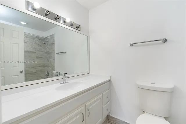 an empty room with wooden floor and a ceiling fan