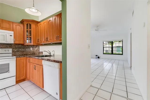 a kitchen with a refrigerator sink and cabinets