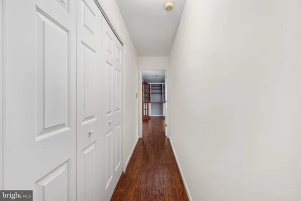 a view of a hallway with wooden floor and closet