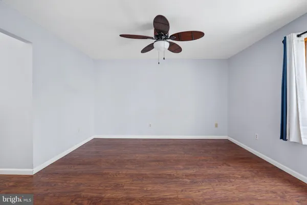 a view of a kitchen and an empty room with closet and a window