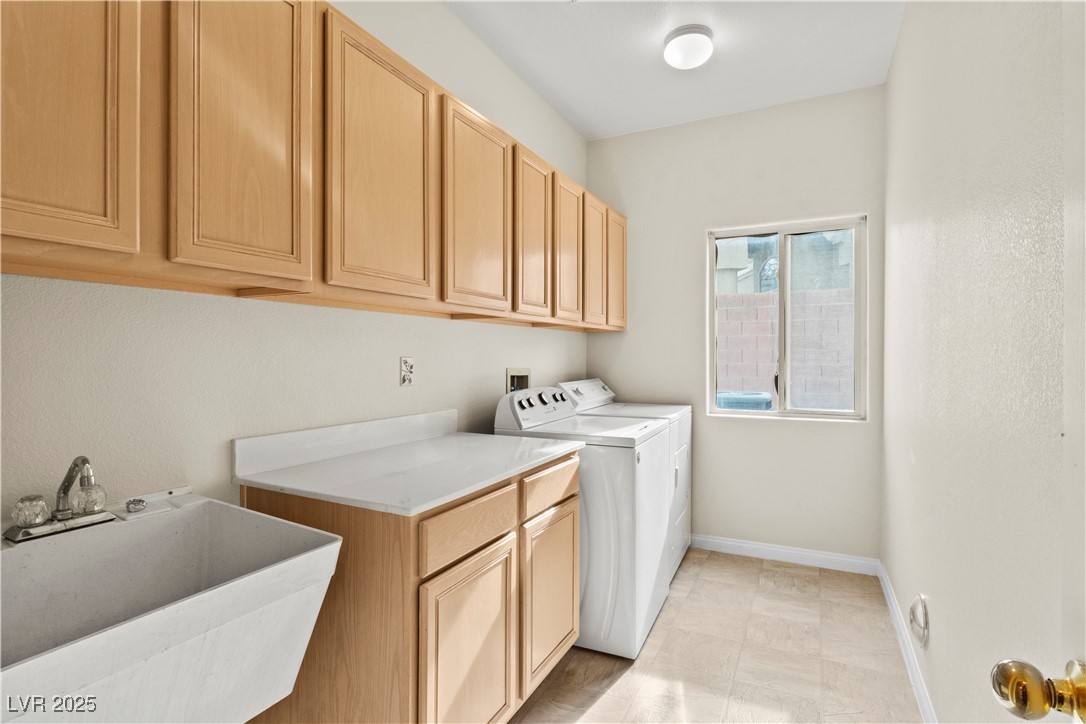 2576 Mizzoni Circle Henderson, NV 89052 - Photo 21 of 44 Laundry room has lots of cabinets and a sink...Washer and dryer remain with the home.