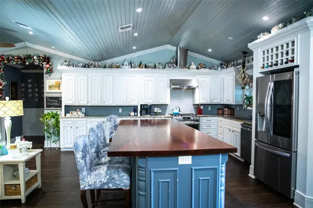 a kitchen with a table chairs refrigerator and cabinets