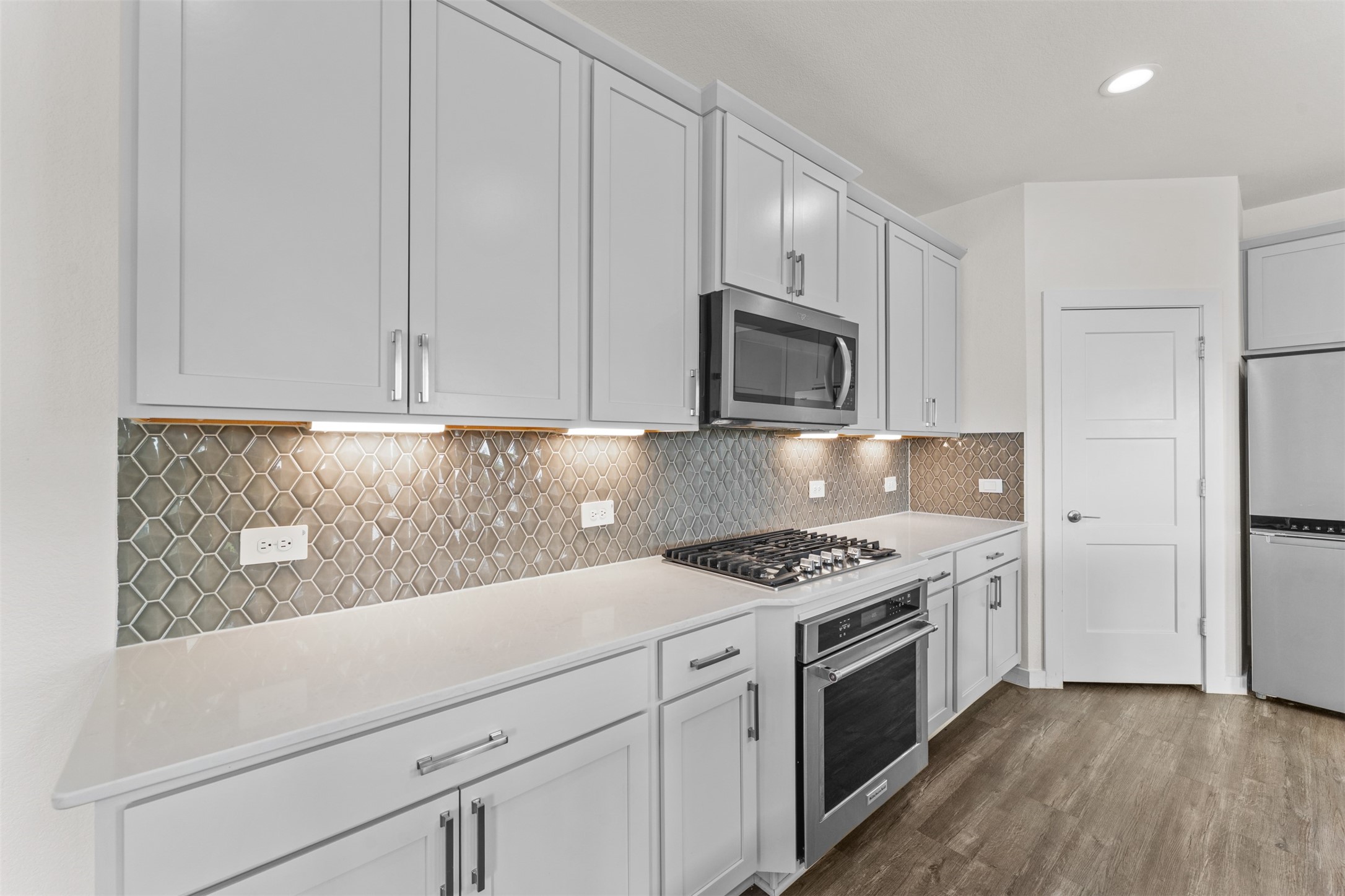 22503 Modica Rift Lane Katy, TX 77449 - Photo 14 of 47 a kitchen with cabinets stainless steel appliances and wooden floor