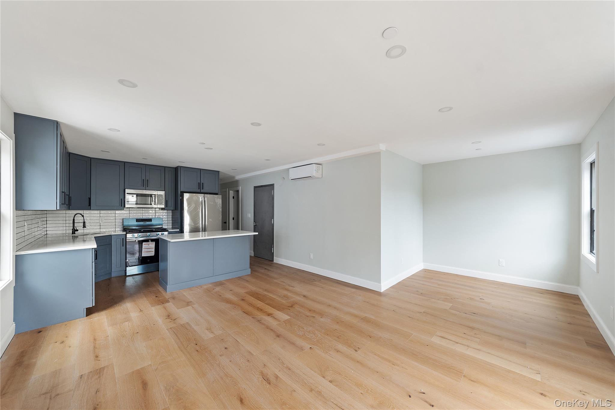 356 South 10th Avenue Mount Vernon, NY 10550 - Photo 30 of 30 a kitchen with stainless steel appliances wooden floors and wooden cabinets
