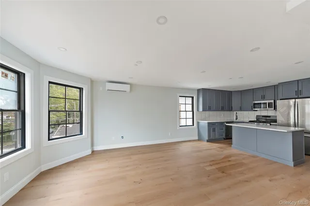 a kitchen with stainless steel appliances wooden floors and wooden cabinets