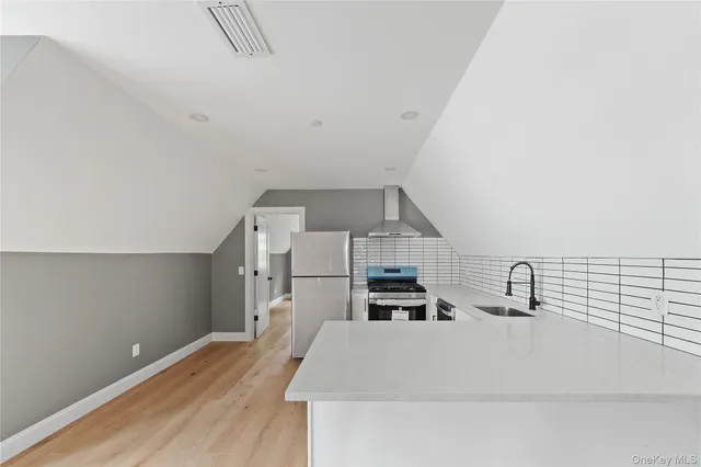 a kitchen with granite countertop a sink cabinets and wooden floor