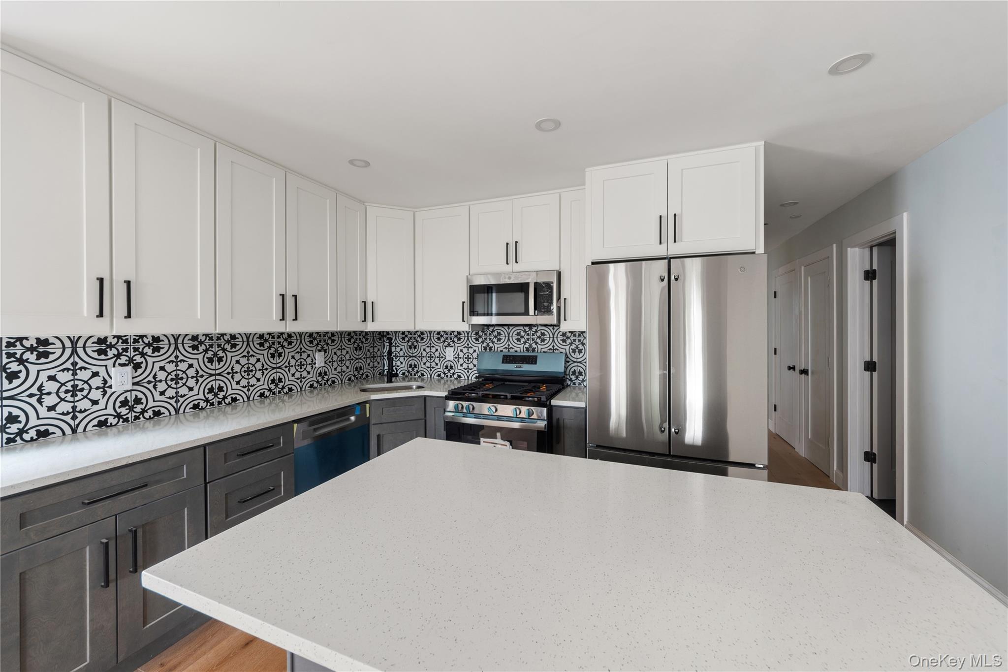 356 South 10th Avenue Mount Vernon, NY 10550 - Photo 27 of 30 a kitchen with granite countertop a refrigerator stove and white cabinets