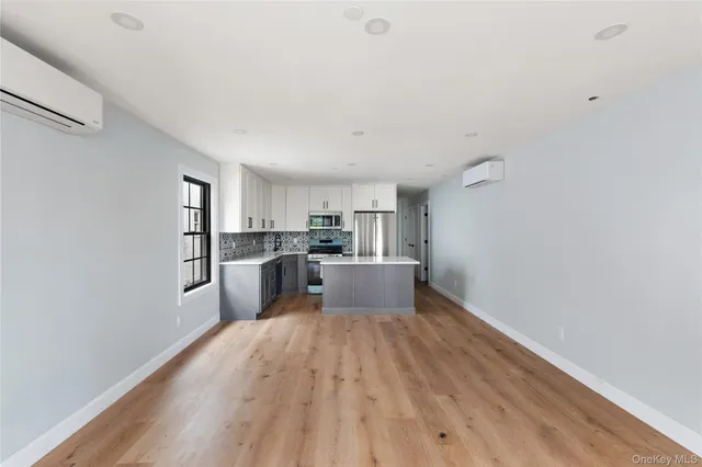 a kitchen with granite countertop a refrigerator stove and white cabinets