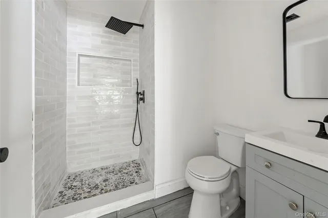 a bathroom with a granite countertop toilet and a sink