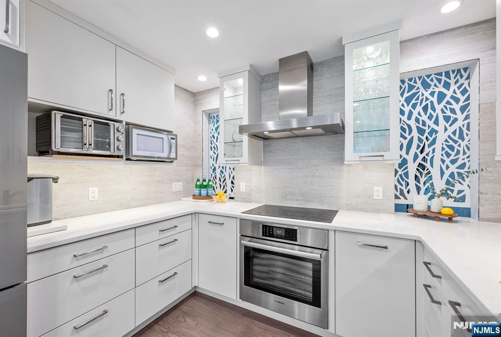 44 Deerfield Terrace Mahwah, NJ 07430 - Photo 15 of 42 a kitchen with stainless steel appliances white cabinets and wooden floors
