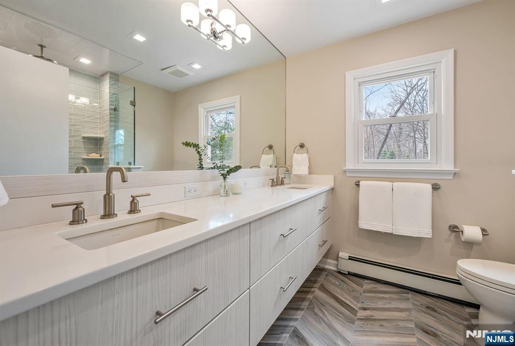 44 Deerfield Terrace Mahwah, NJ 07430 - Photo 27 of 42 a bathroom with a double vanity sink a toilet and a mirror
