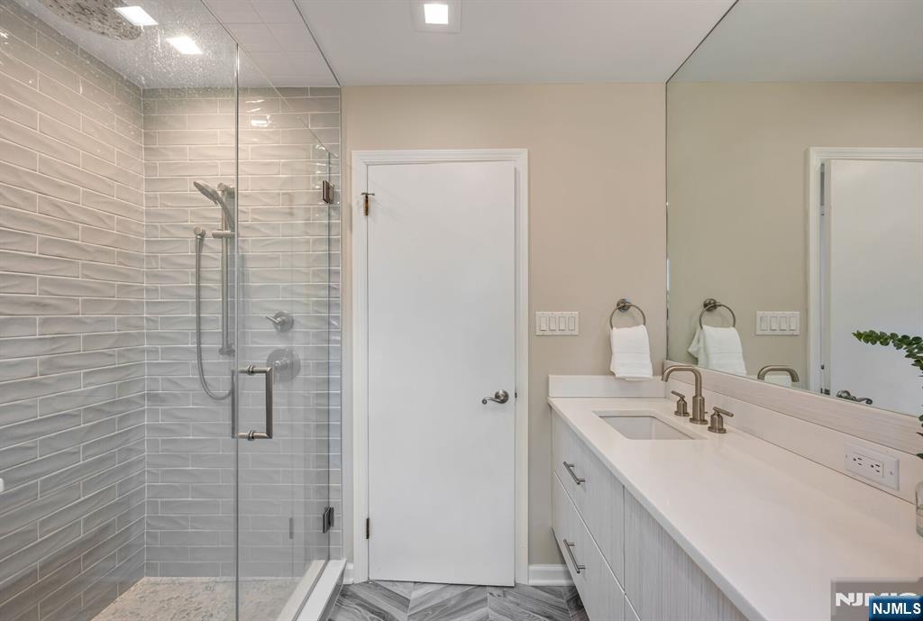 44 Deerfield Terrace Mahwah, NJ 07430 - Photo 29 of 42 a bathroom with a shower sink and mirror
