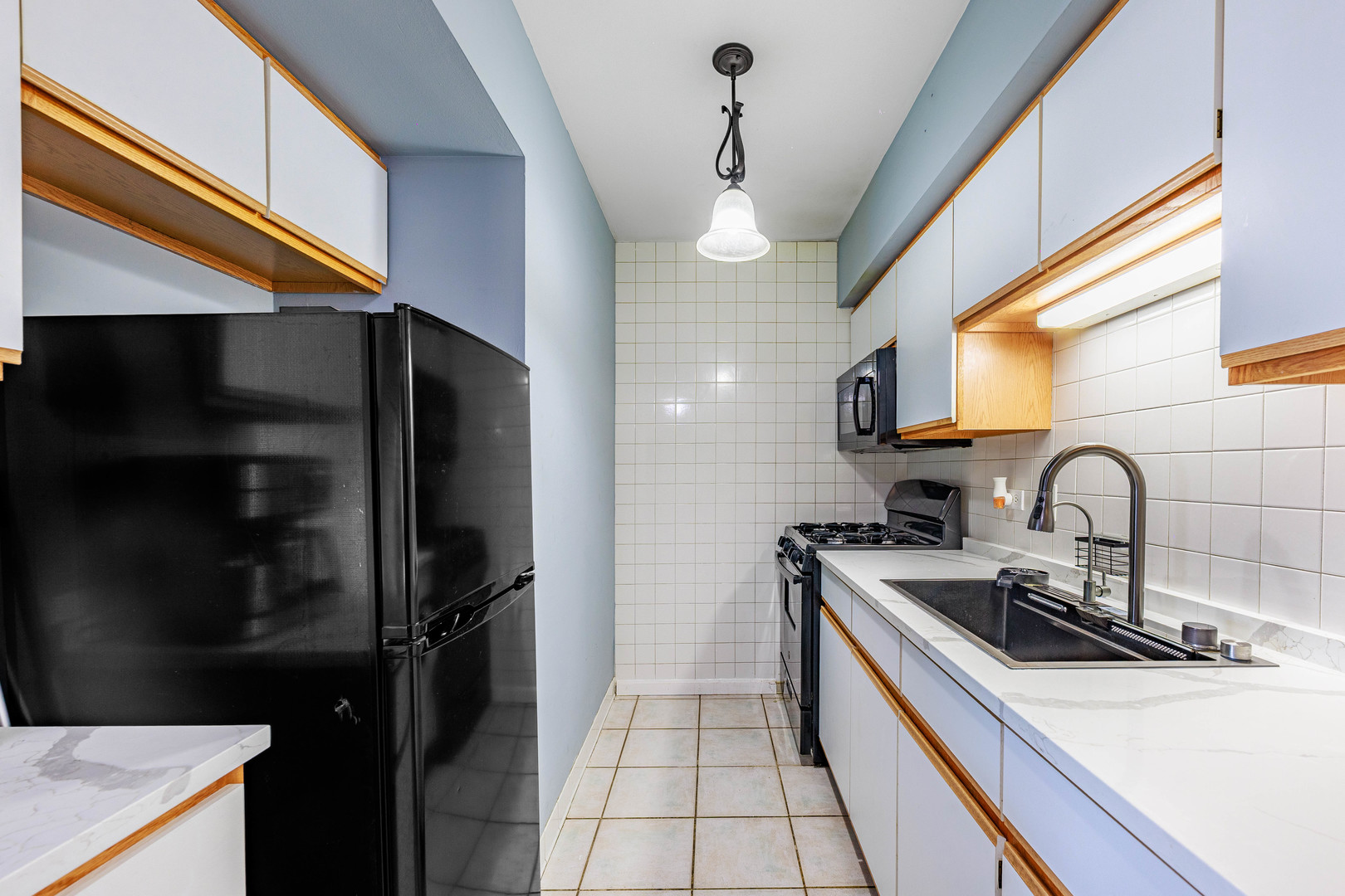 11036 Kilpatrick Avenue, Unit 3SW Oak Lawn, IL 60453 - Photo 8 of 19 a kitchen with stainless steel appliances a sink a stove a refrigerator and cabinets