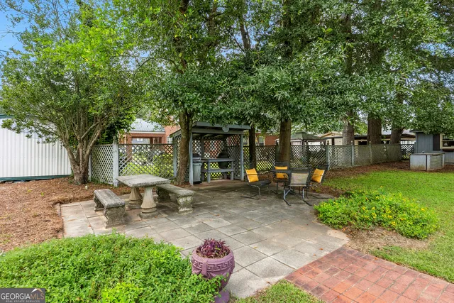a view of backyard with wooden fence and trees