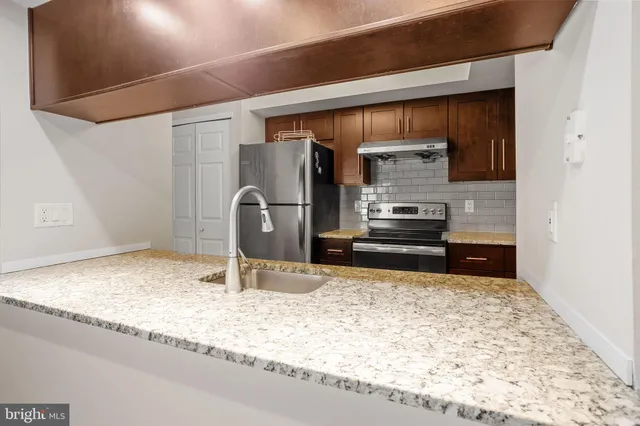 a kitchen with kitchen island sink refrigerator and stove