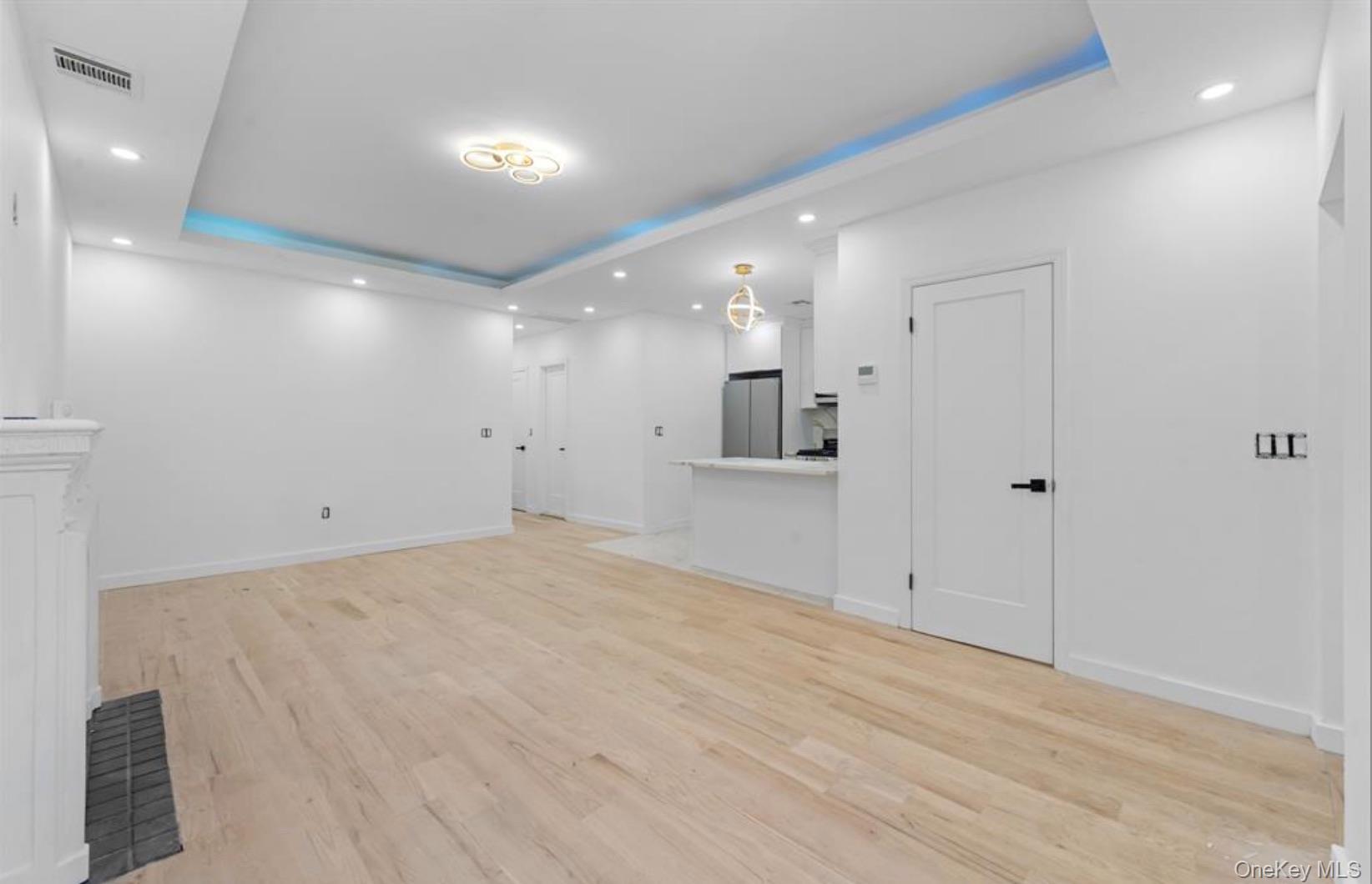 752 Lenox Road Brooklyn, NY 11203 - Photo 11 of 14 Unfurnished living room with a raised ceiling, recessed lighting, and light wood-style flooring