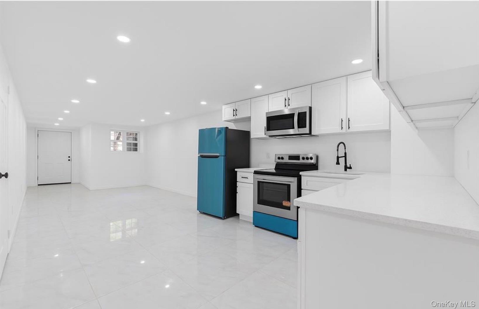 752 Lenox Road Brooklyn, NY 11203 - Photo 13 of 14 Kitchen with stainless steel appliances, white cabinets, recessed lighting, and light stone counters
