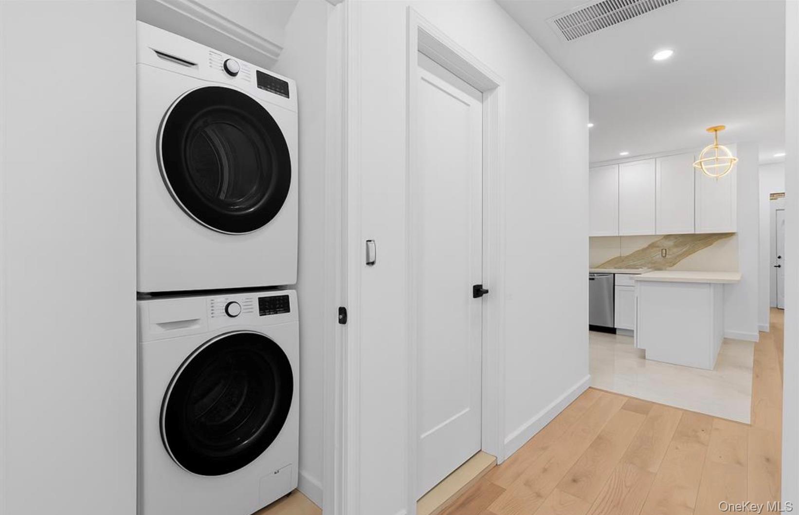 752 Lenox Road Brooklyn, NY 11203 - Photo 4 of 14 Laundry area featuring light wood finished floors, stacked washer / dryer, and recessed lighting