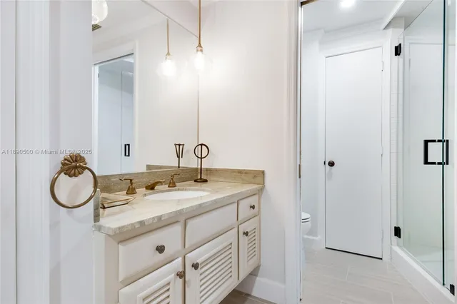 a bathroom with a granite countertop sink and a mirror