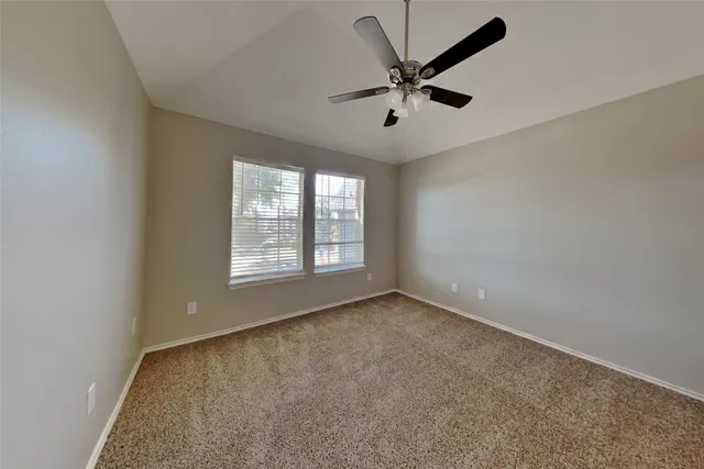 a view of a big room with windows and chandelier fan