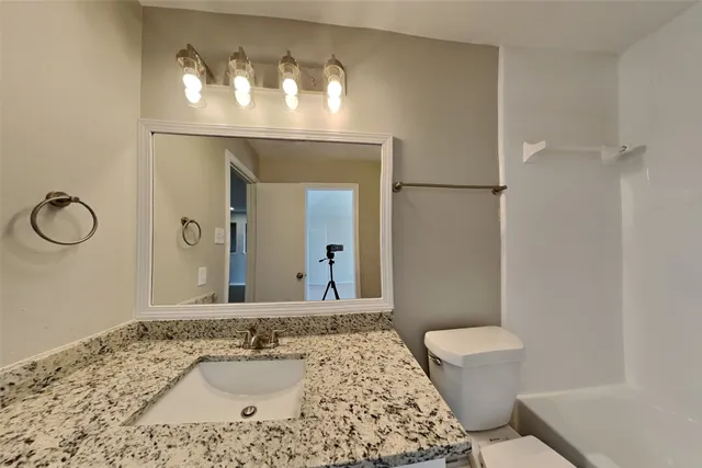 a bathroom with a sink a toilet and mirror