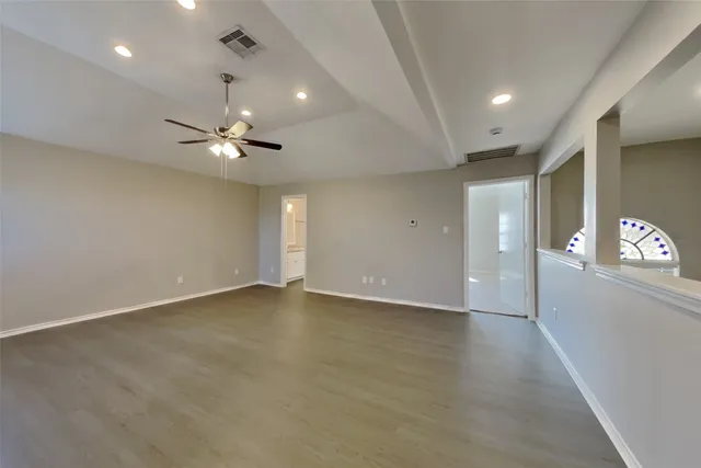 an empty room with window and wooden floor