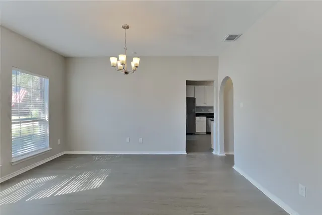 a view of a big room with windows and chandelier