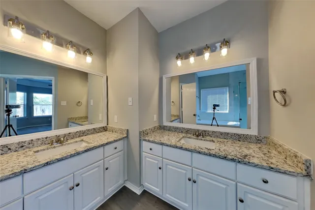 a bathroom with double vanity sinks and a large mirror
