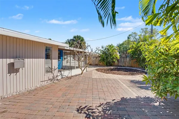 a view of a house with a small yard and wooden fence