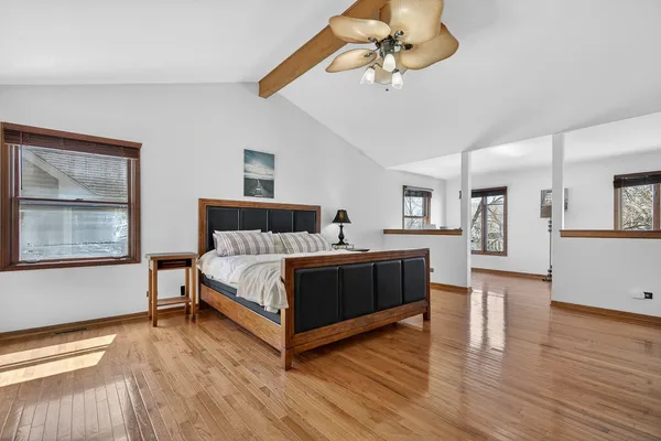 a spacious bedroom with a bed and a chandelier