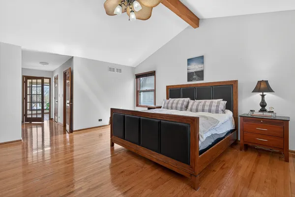 a bedroom with a bed and wooden floor