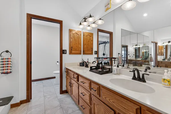 a bathroom with double vanity sinks a vanity a mirror and a shower