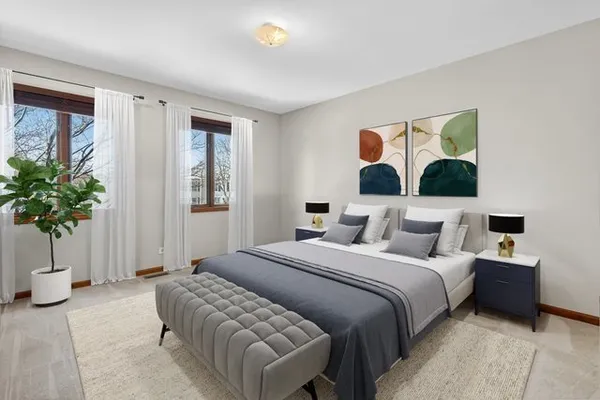 a bedroom with a large bed and a potted plant