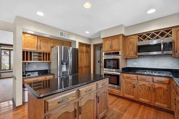 a kitchen with stainless steel appliances granite countertop a refrigerator and a stove top oven