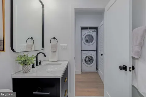a bathroom with a granite countertop sink a toilet a mirror a vanity and bathtub