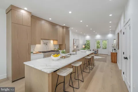 a kitchen with a table chairs wooden floor and a view of kitchen