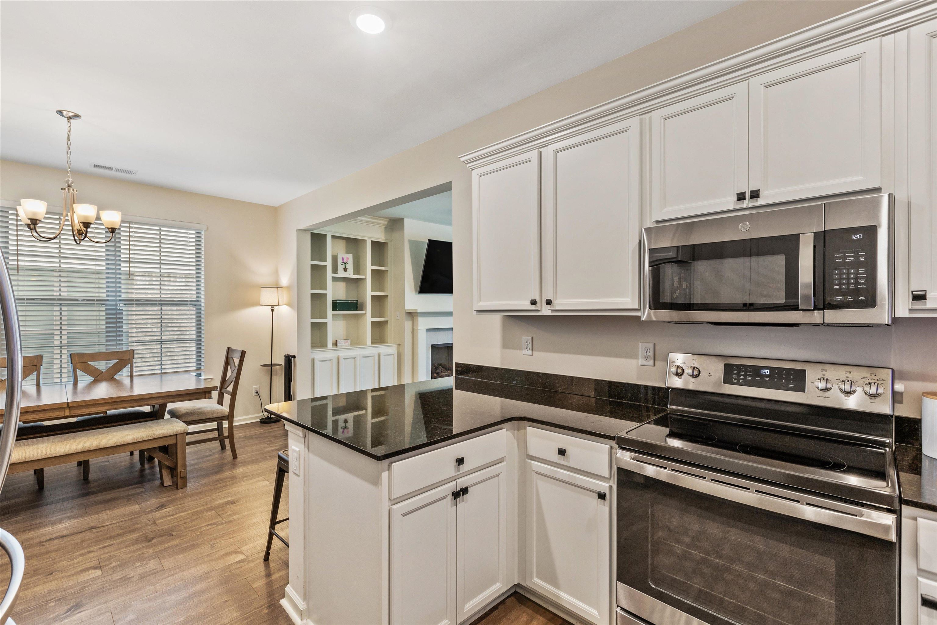 10139 Macon Road Cordova, TN 38018 - Photo 11 of 31 Kitchen featuring white cabinetry, dark countertops, stainless steel appliances, and wood-finish flooring