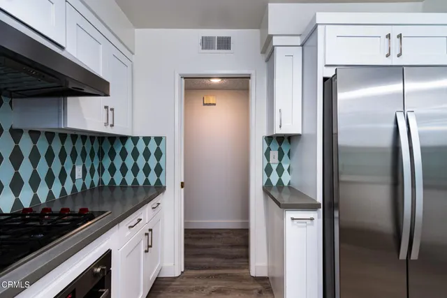 a kitchen with stainless steel appliances granite countertop a refrigerator and a stove