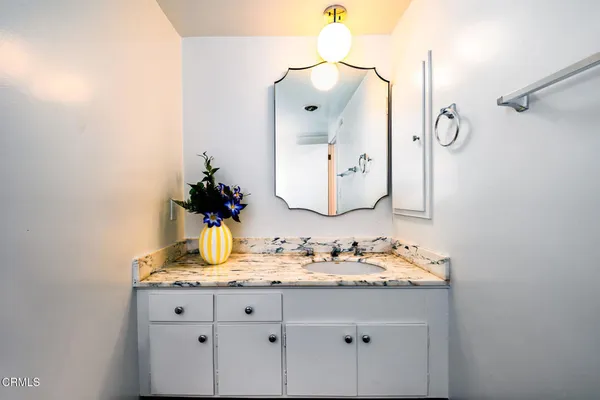 a bathroom with a granite countertop sink and a mirror