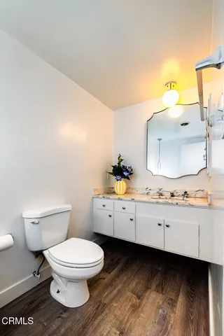 a view of a livingroom with wooden floor and kitchen space