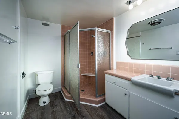 a bathroom with a toilet a sink and mirror