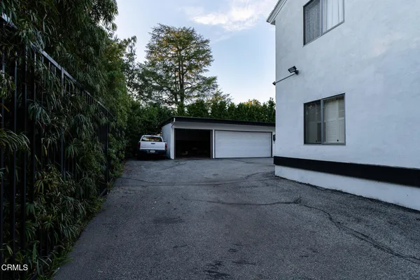 a view of a house with a yard and a large tree