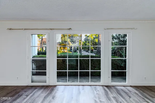 a view of empty room with wooden floor and windows